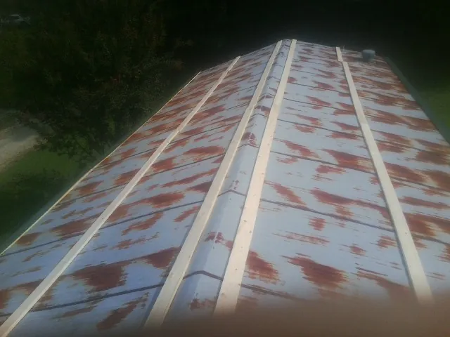 Rusted metal roof panels with new wood purlins before replacement — Storm Damage Roof Repair in Coquille by Roofing Brothers