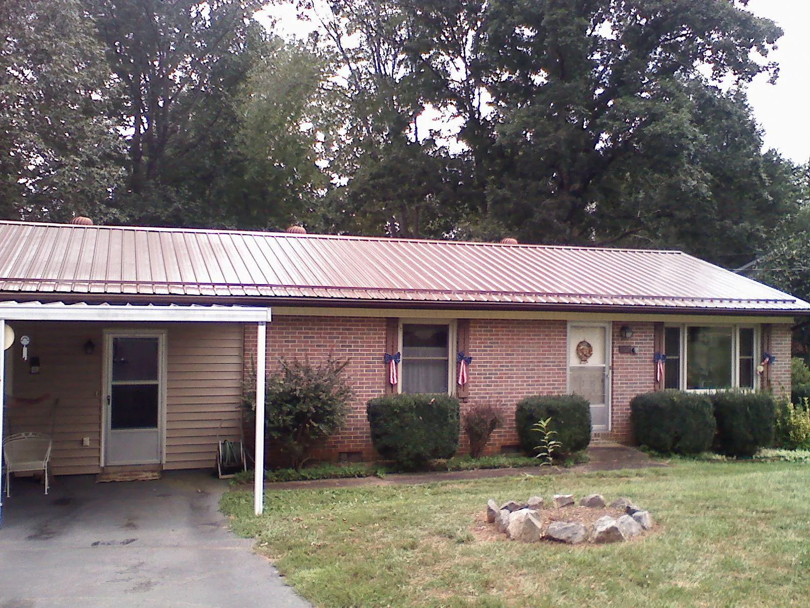 Bronze metal roof and carport on a brick ranch home — Roof Repair work by our crew in Coquille