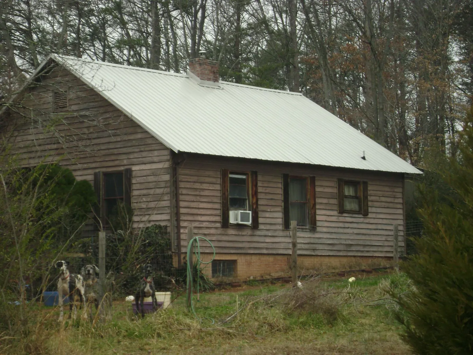 White metal roof on an old wood sided farmhouse, from a Metal Roof Installation job in Coquille